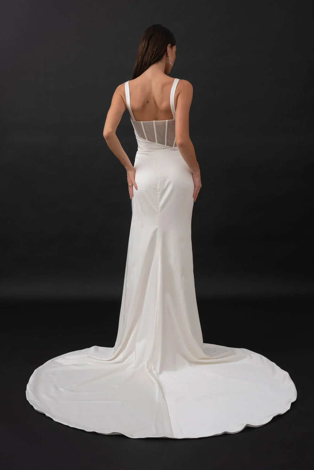 back of evie young gia ivory satin sheath wedding dress showing the sheer back and slim skirt with a chapel length train