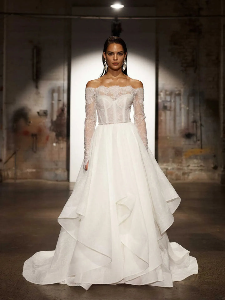 full front of evie young hollis ivory organza ball gown wedding dress with a matching long sleeve lace jacket