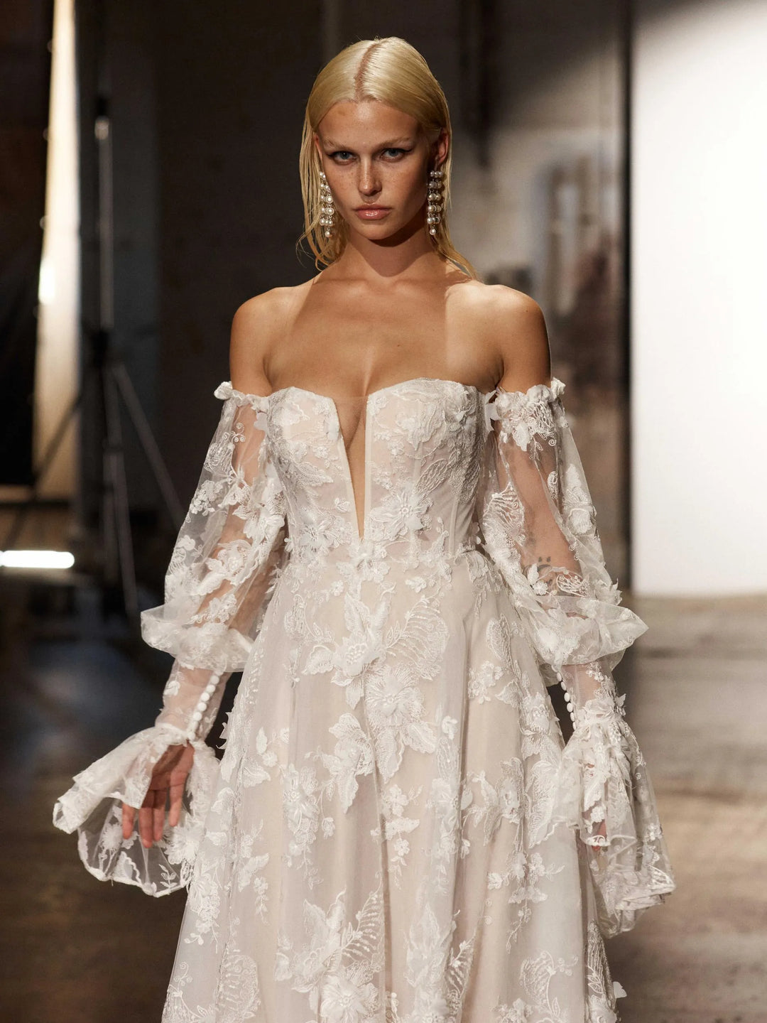 close up of evie young montana ivory lace a-line wedding dress showing the plunge neckline and detached long sleeves