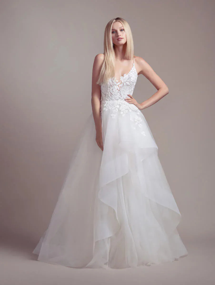 Woman wearing a white wedding dress against a plain background