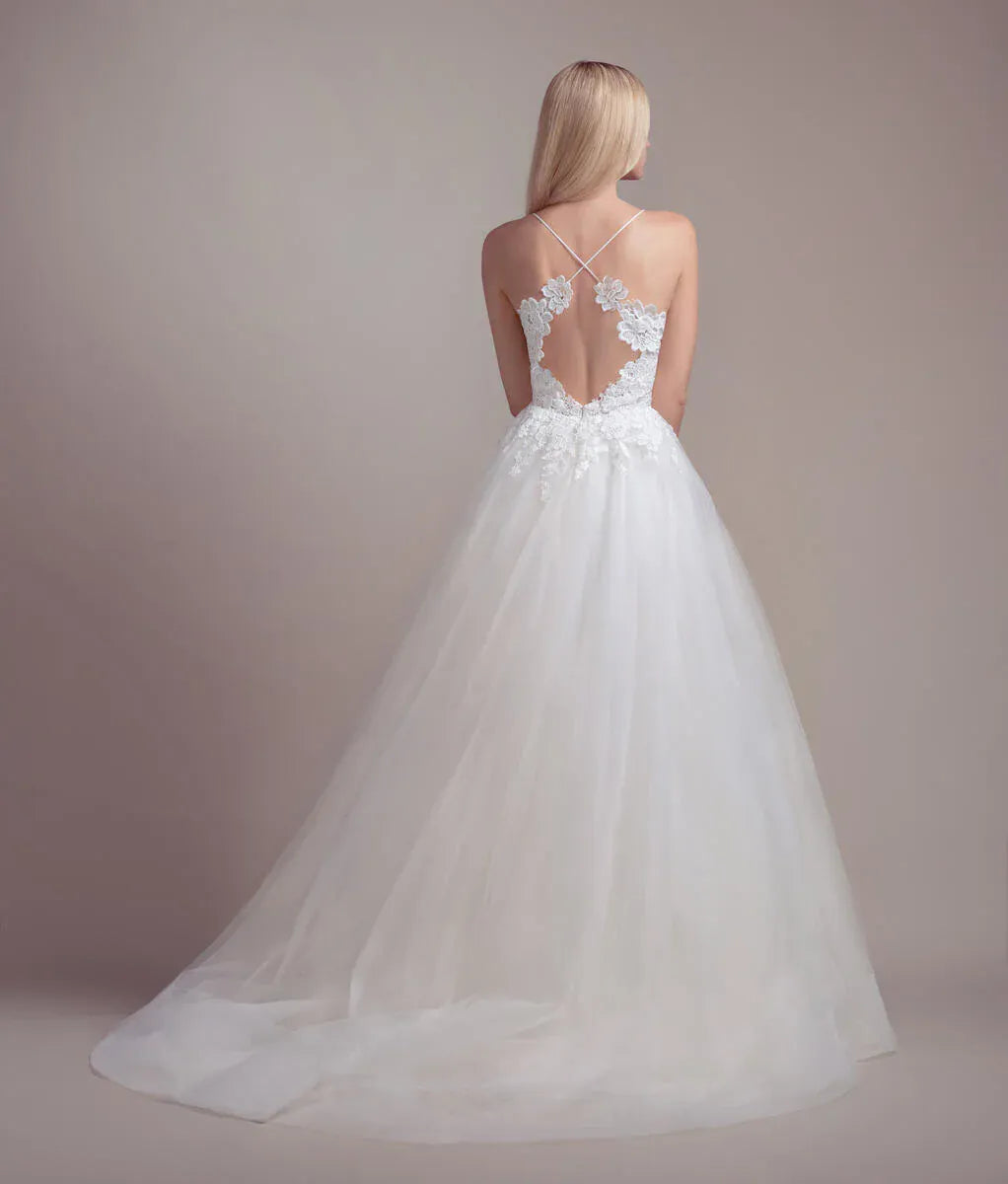 White wedding dress with floral lace details on a plain background