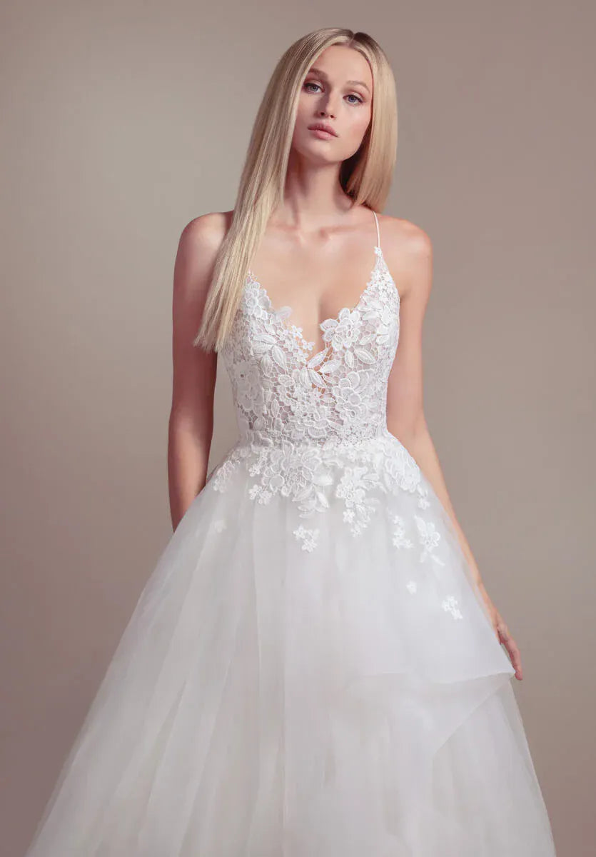 White wedding dress with floral details on a plain background