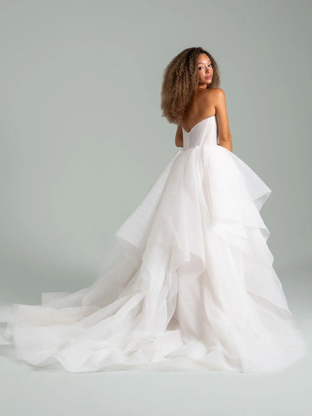 full back of hayley paige once i was a swan ivory tulle ball gown wedding dress with tiered skirt and a long train