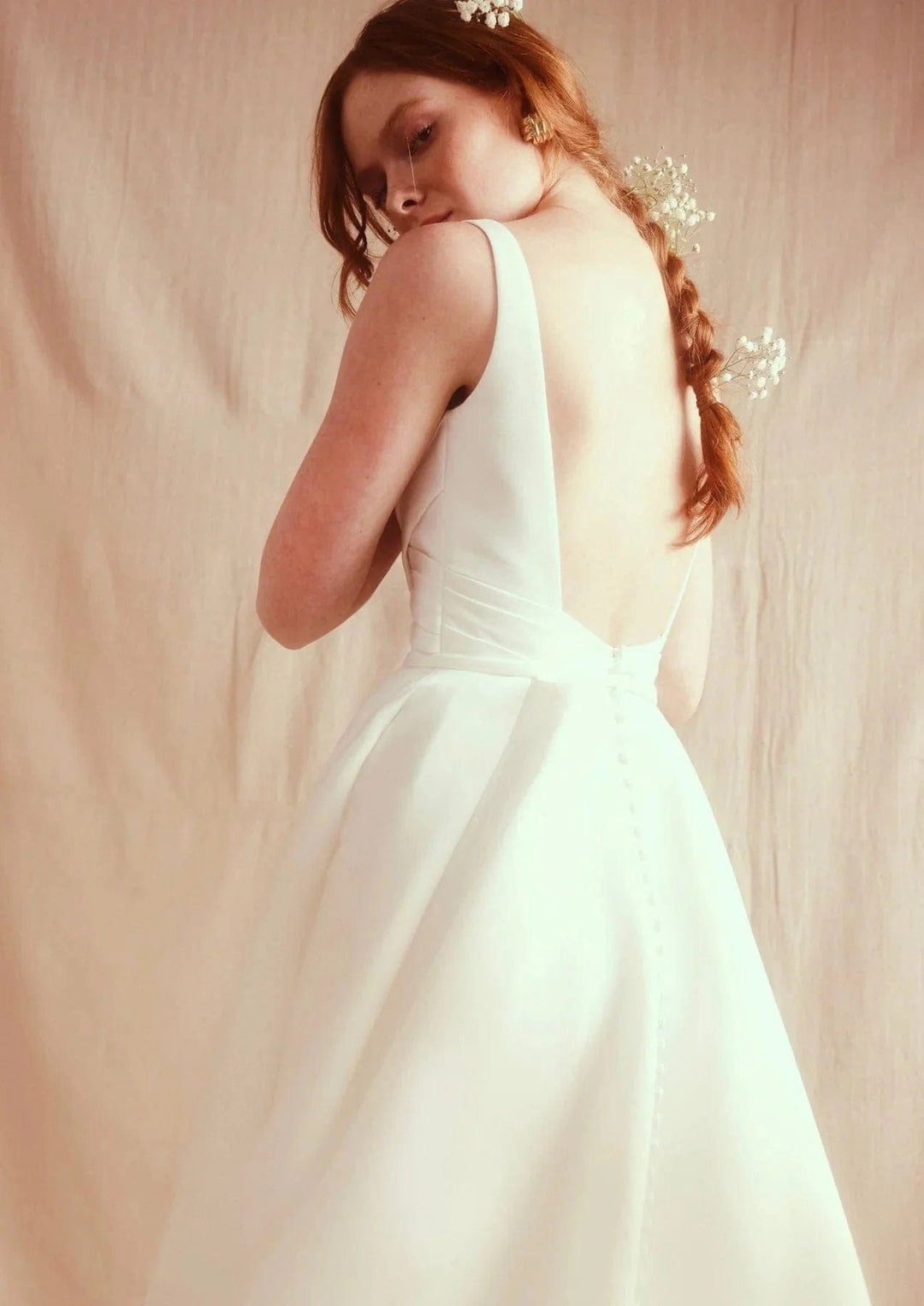 Woman in a white dress with a plain background
