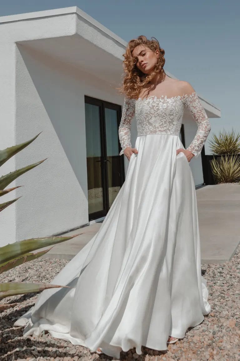 front of jenny yoo bradley ivory mikado a-line wedding dress, showing the off the shoulder lace bodice with long sleeves, and flowy skirt