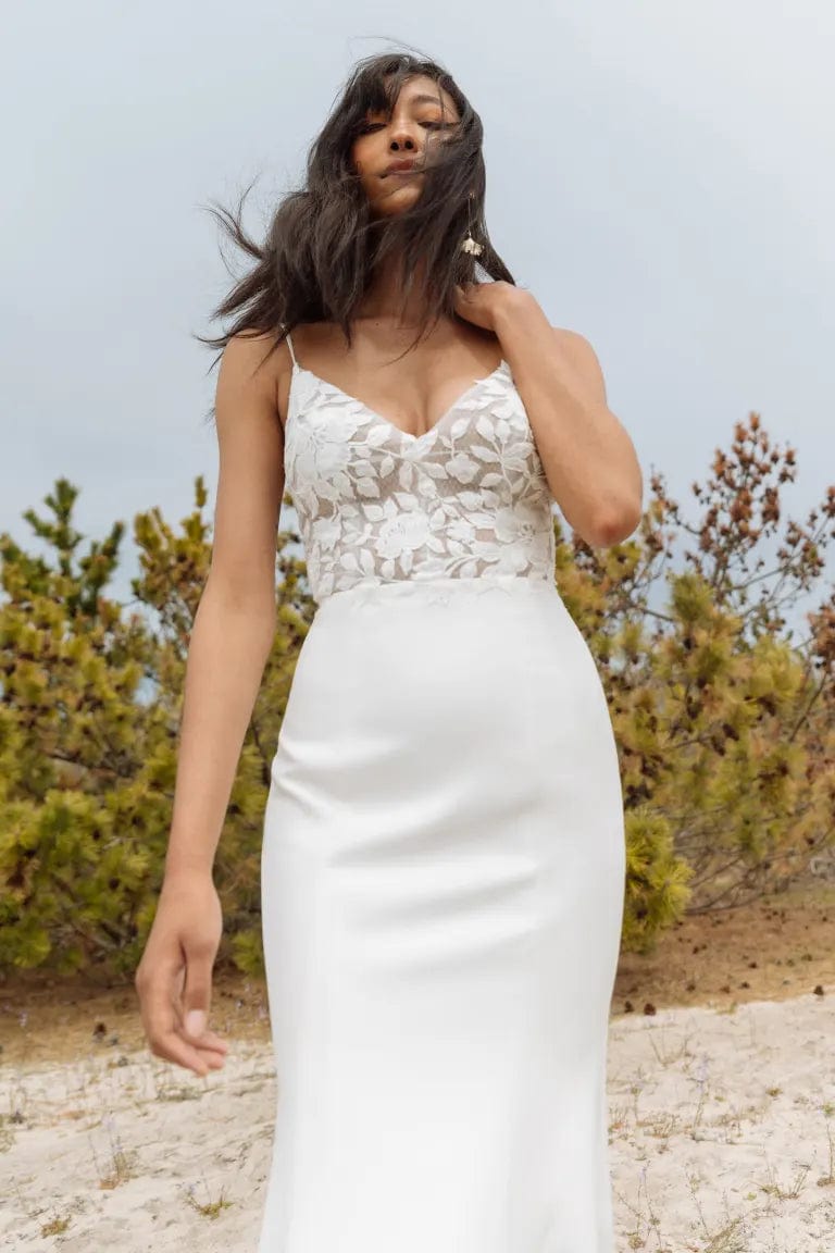 close up of the bodice of jenny yoo christina ivory crepe fitted wedding dress with a lace applique bodice and v neckline