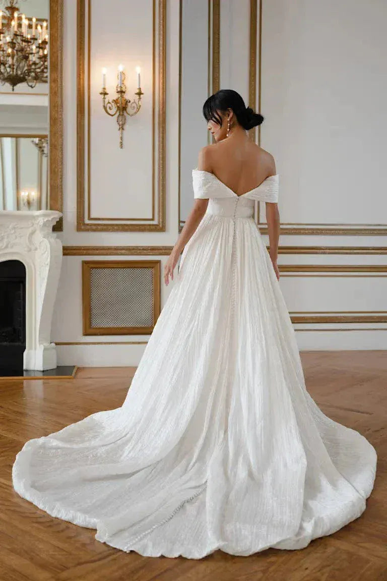full back of jenny yoo farrow ivory organza ball gown with textured fabric and an off the shoulder neckline, and a chapel length train