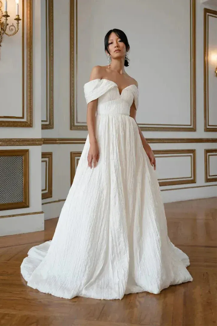 full front of jenny yoo farrow ivory organza ball gown with textured fabric and an off the shoulder neckline