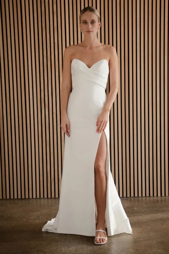 front of jenny yoo lola ivory crepe fitted wedding dress with a strapless sweetheart neckline and slit in the skirt