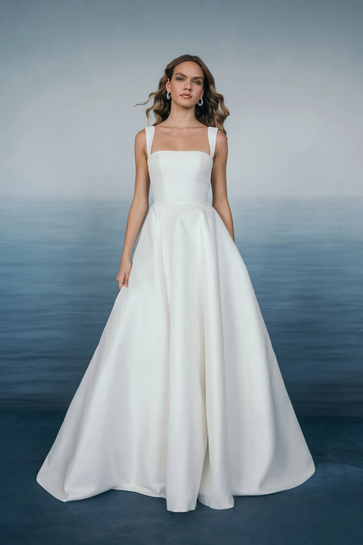 Woman wearing a white wedding dress against a gradient background