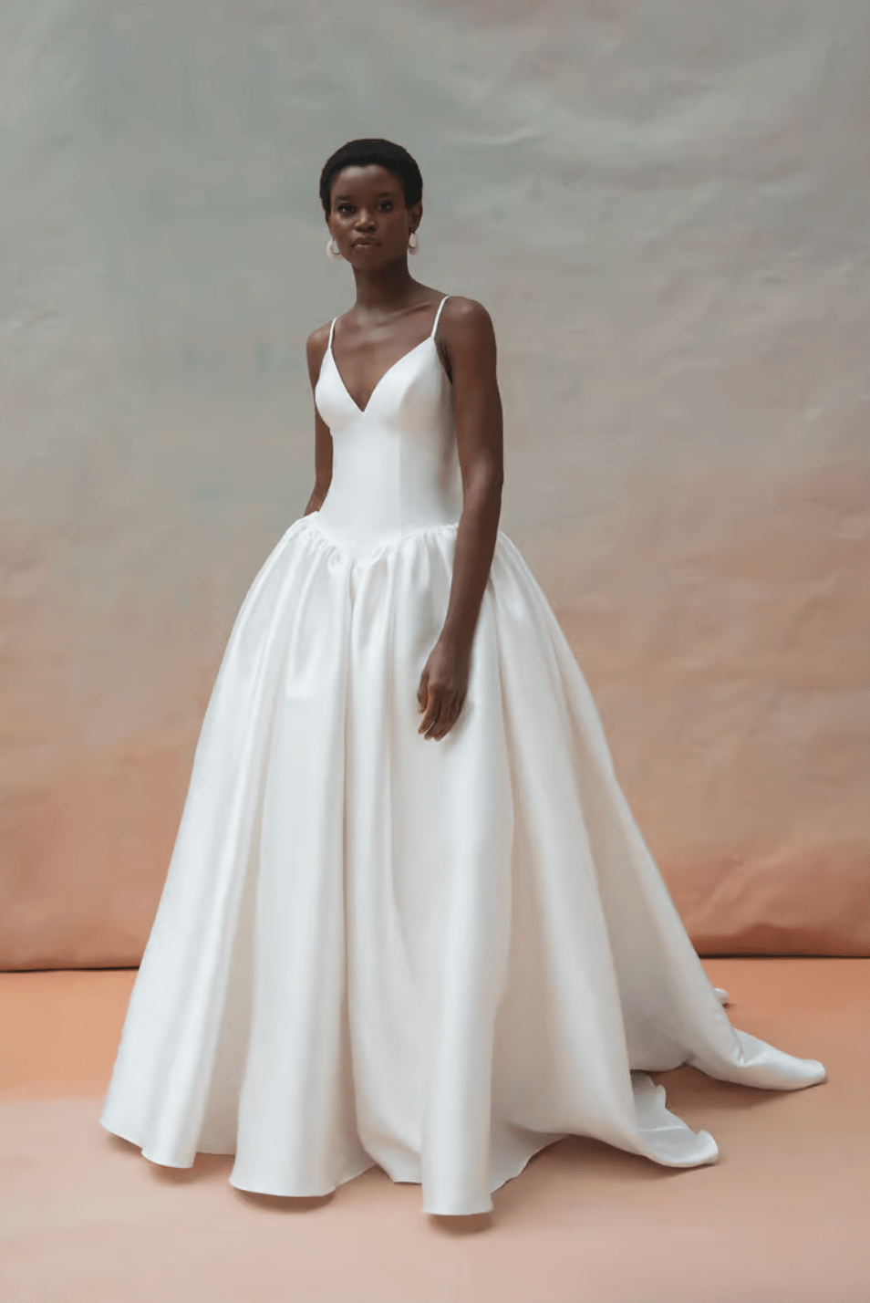 Woman wearing a white wedding dress against a neutral background