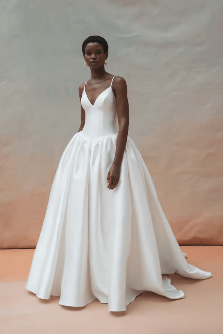 Woman wearing a white wedding dress against a neutral background