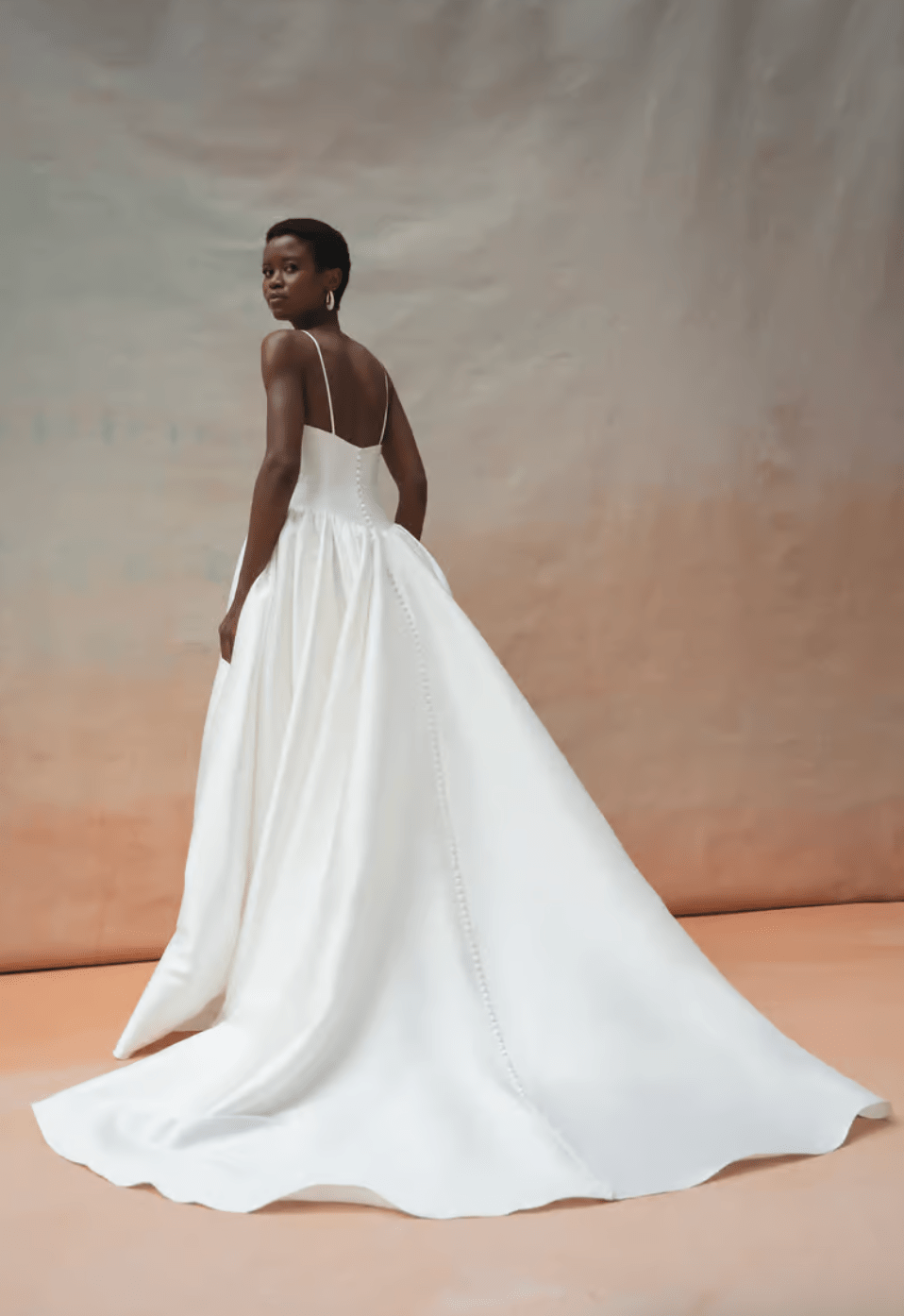 Woman wearing a white wedding dress against a neutral background