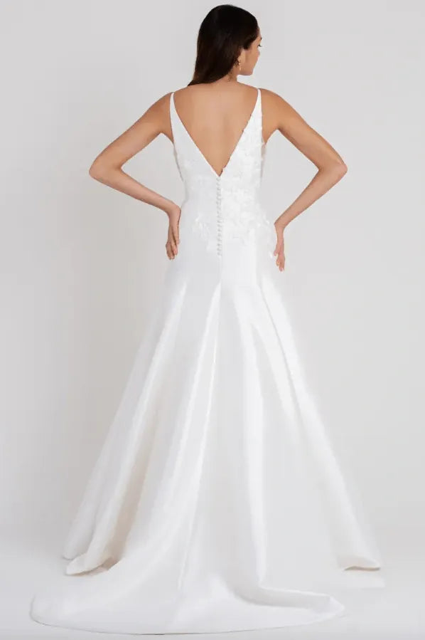 White wedding dress with a deep V-neckline and open back on a white background