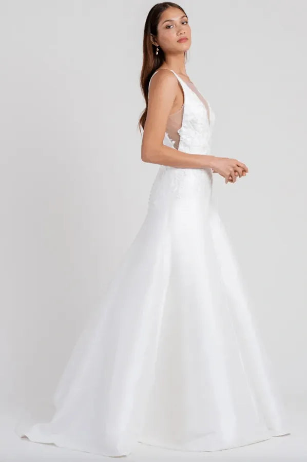 Woman wearing a white dress on a plain background