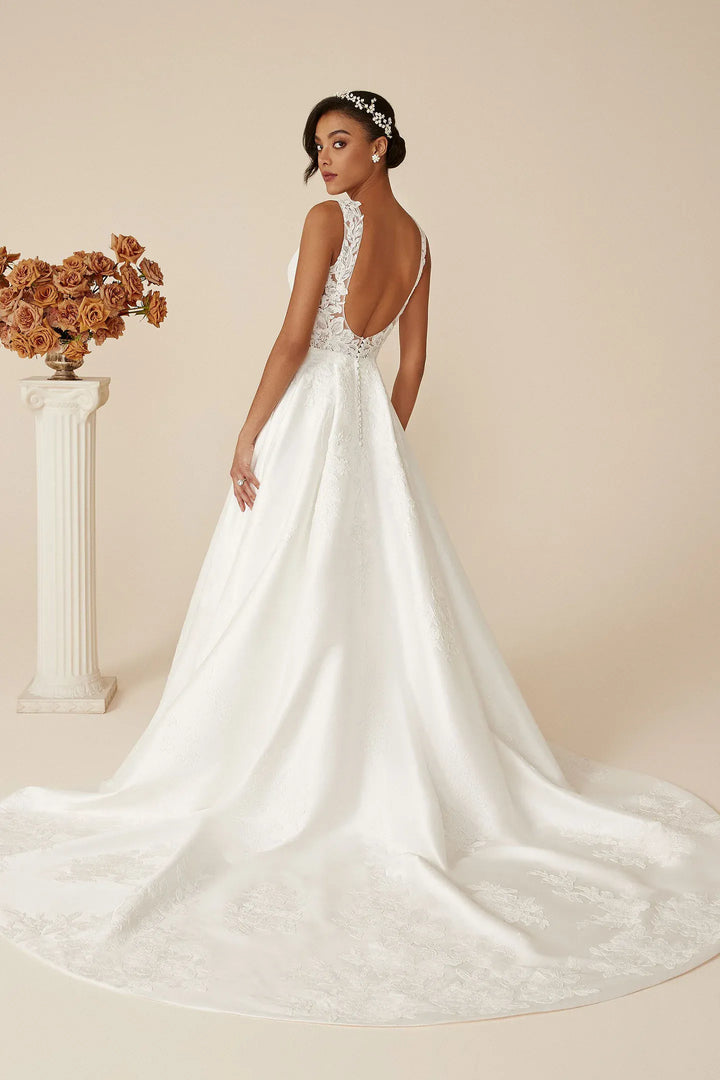 Woman in a white wedding dress with a floral arrangement on a beige background