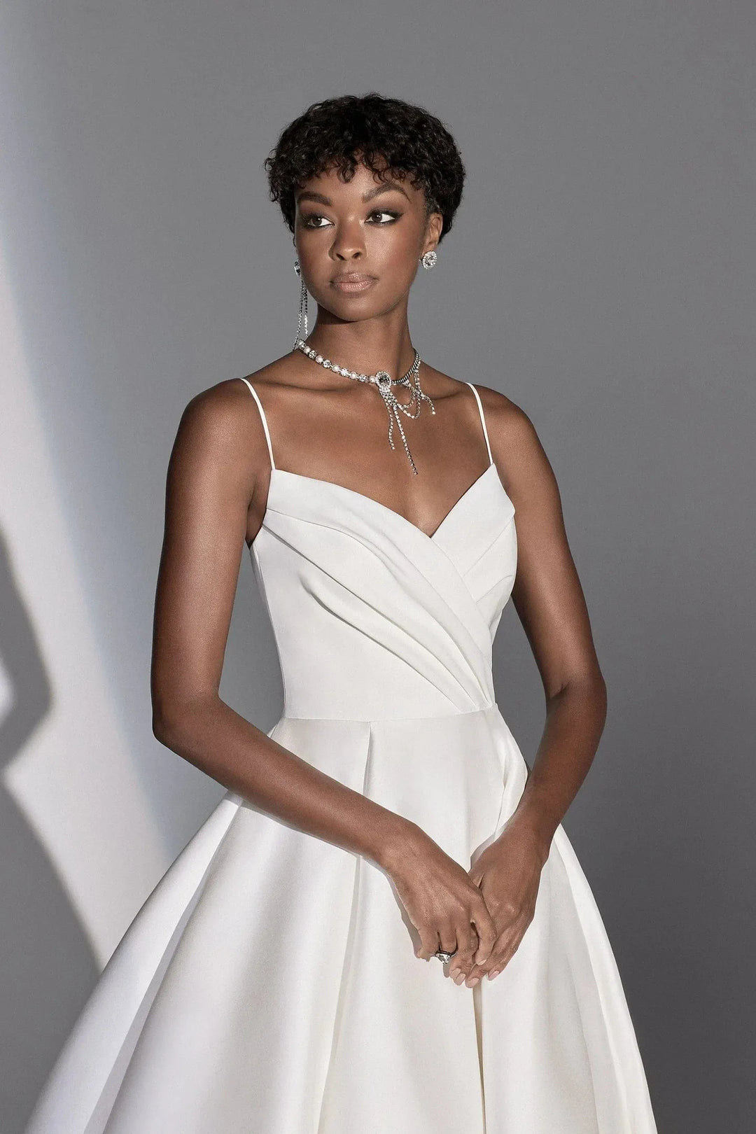 Woman wearing a white dress against a gray background