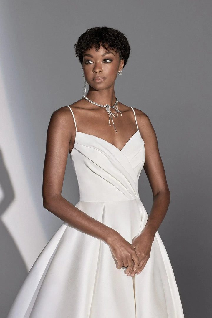 Woman wearing a white dress against a gray background