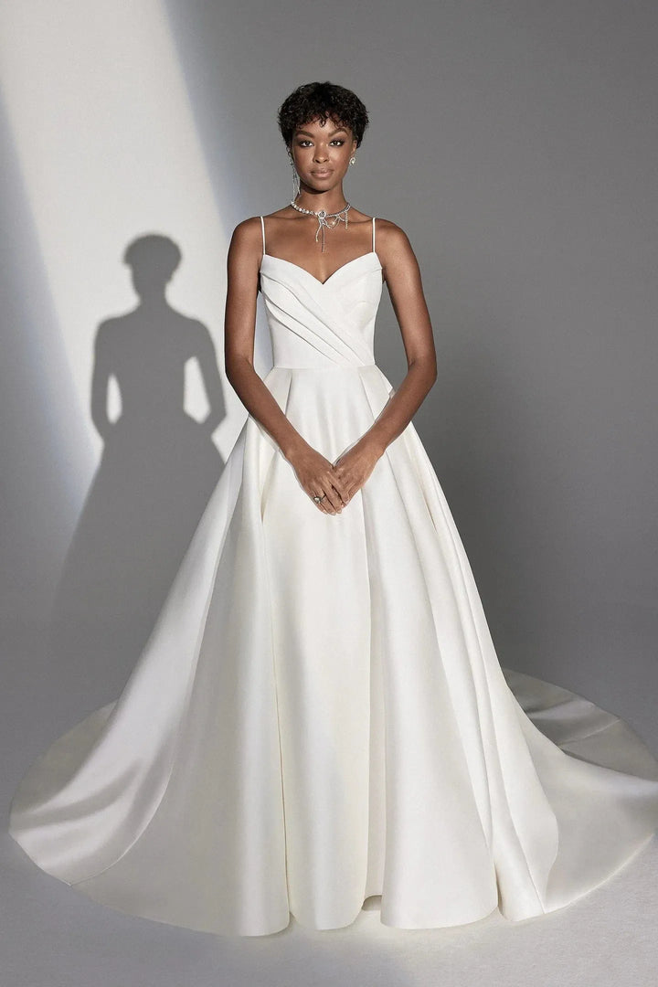 Woman wearing a white wedding dress against a gray background