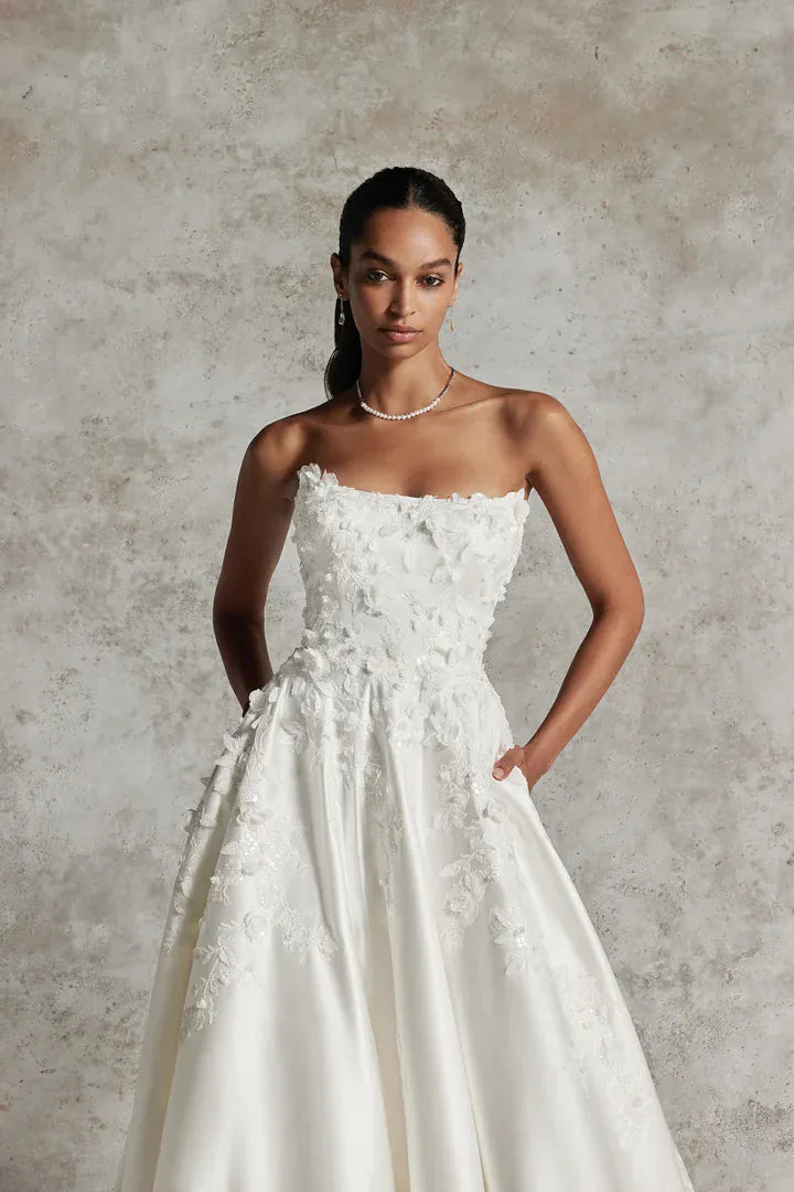 close up of justin alexander 99291 ivory satin a-line wedding dress showing the dimensional floral accents on the bodice 