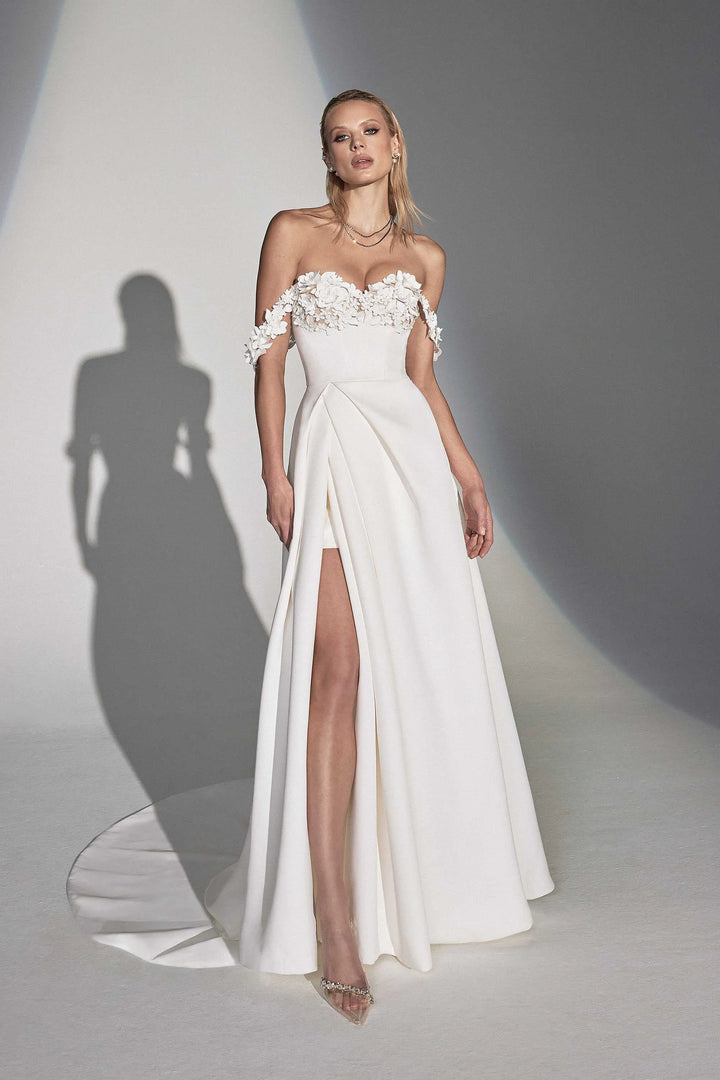 White strapless gown with floral details on a plain background