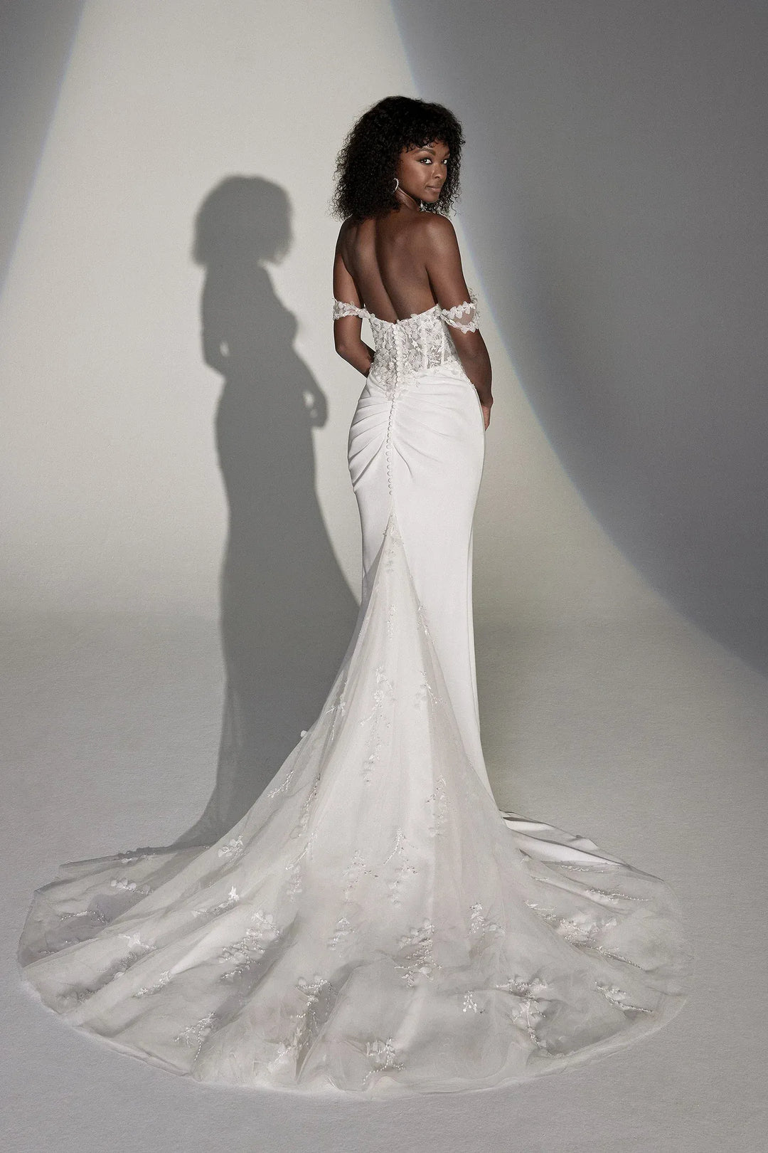 White wedding dress with intricate detailing on a plain background