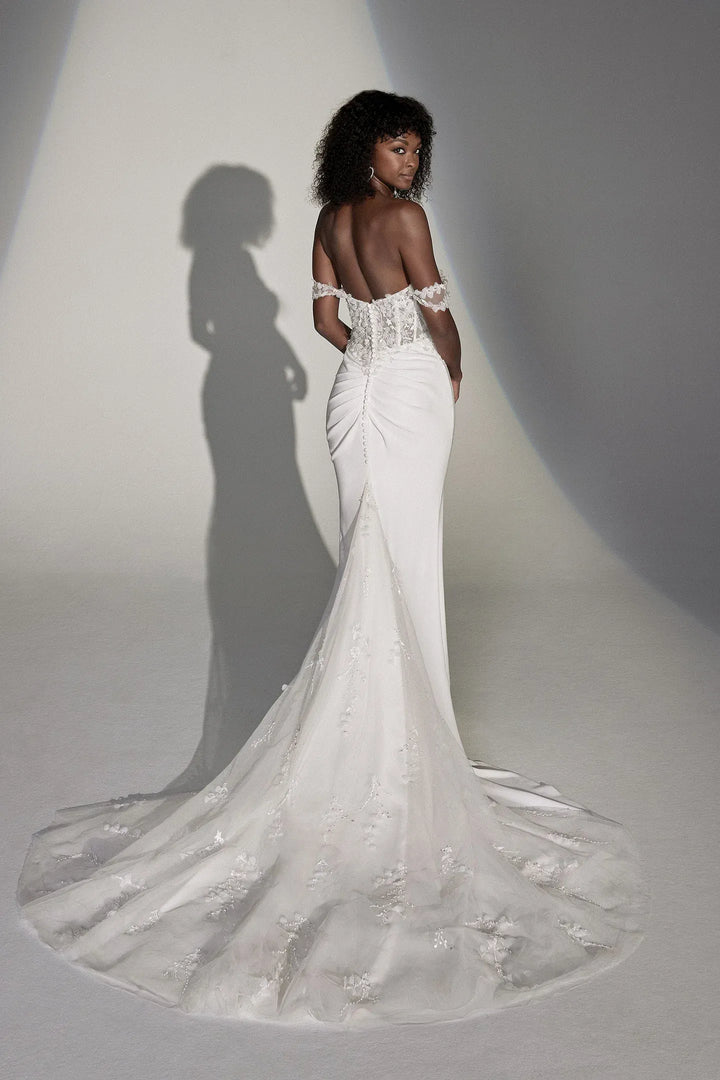 White wedding dress with intricate detailing on a plain background