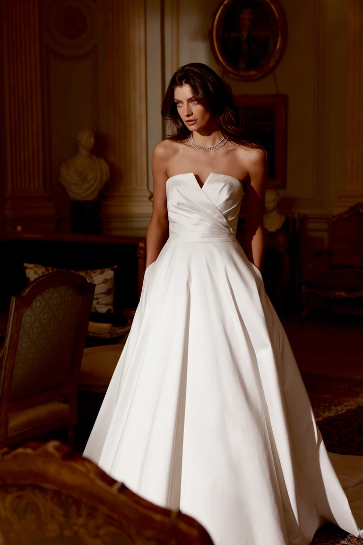 front of justin alexander jones ivory mikado a-line wedding dress with notched v neckline + pockets in the skirt