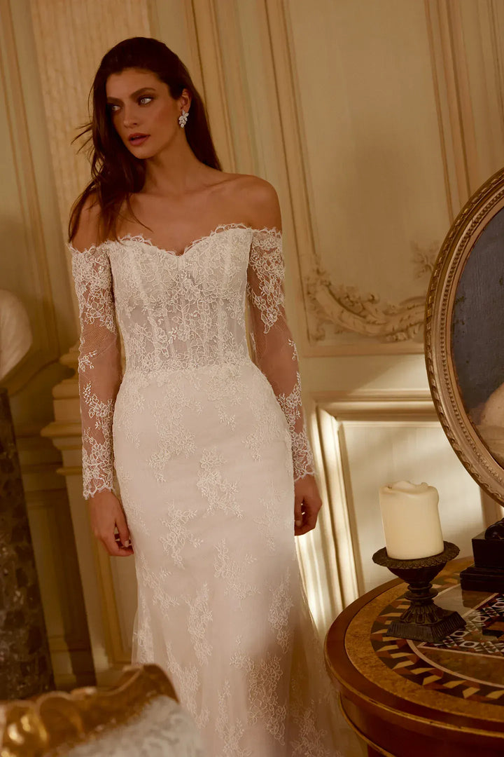 Woman wearing a white lace wedding dress in an elegant room.