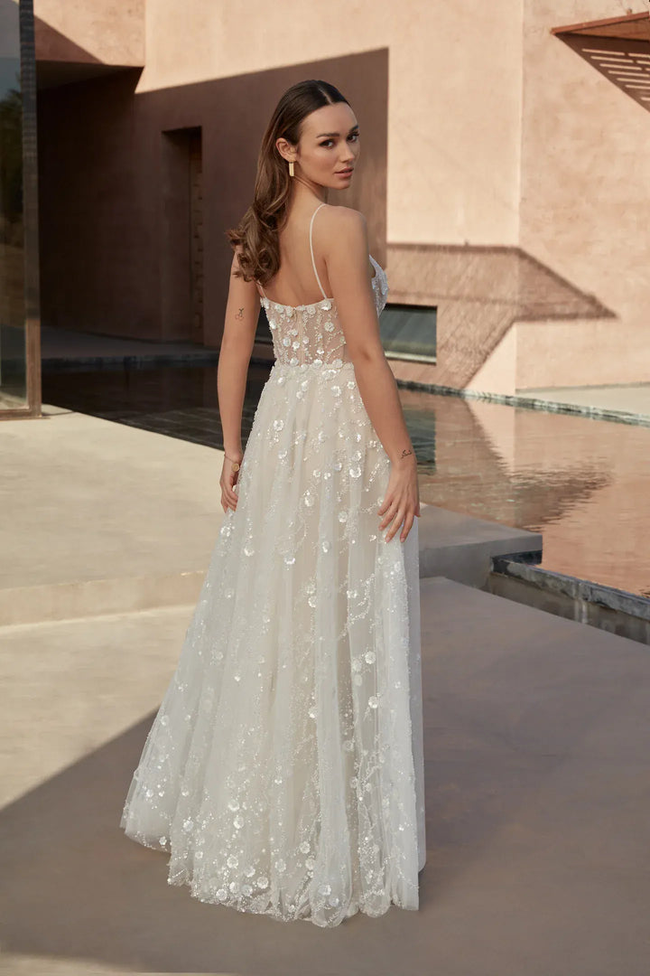 Woman in a white lace dress standing in front of a modern architectural background