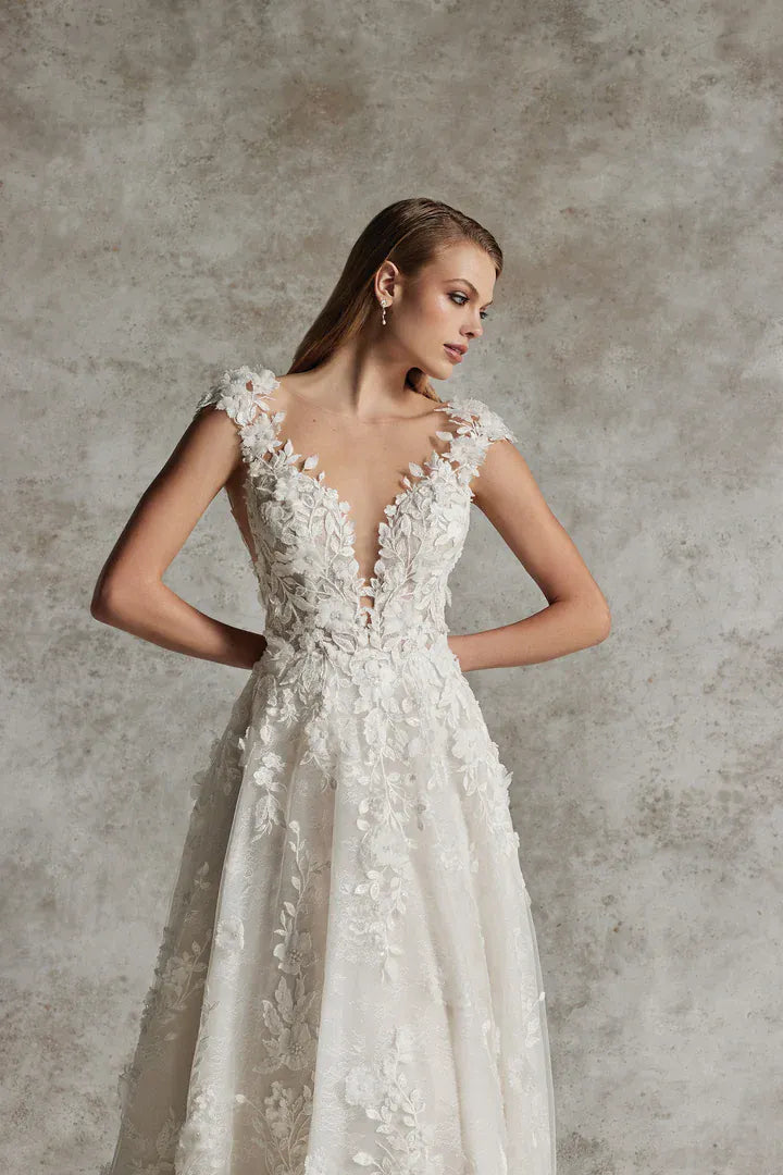 close up of justin alexander venetia nude tulle a-line wedding dress covered in floral lace accents throughout, showing the plunging neckline