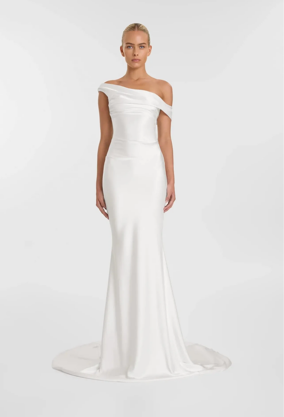Woman wearing a white off-shoulder gown on a plain background