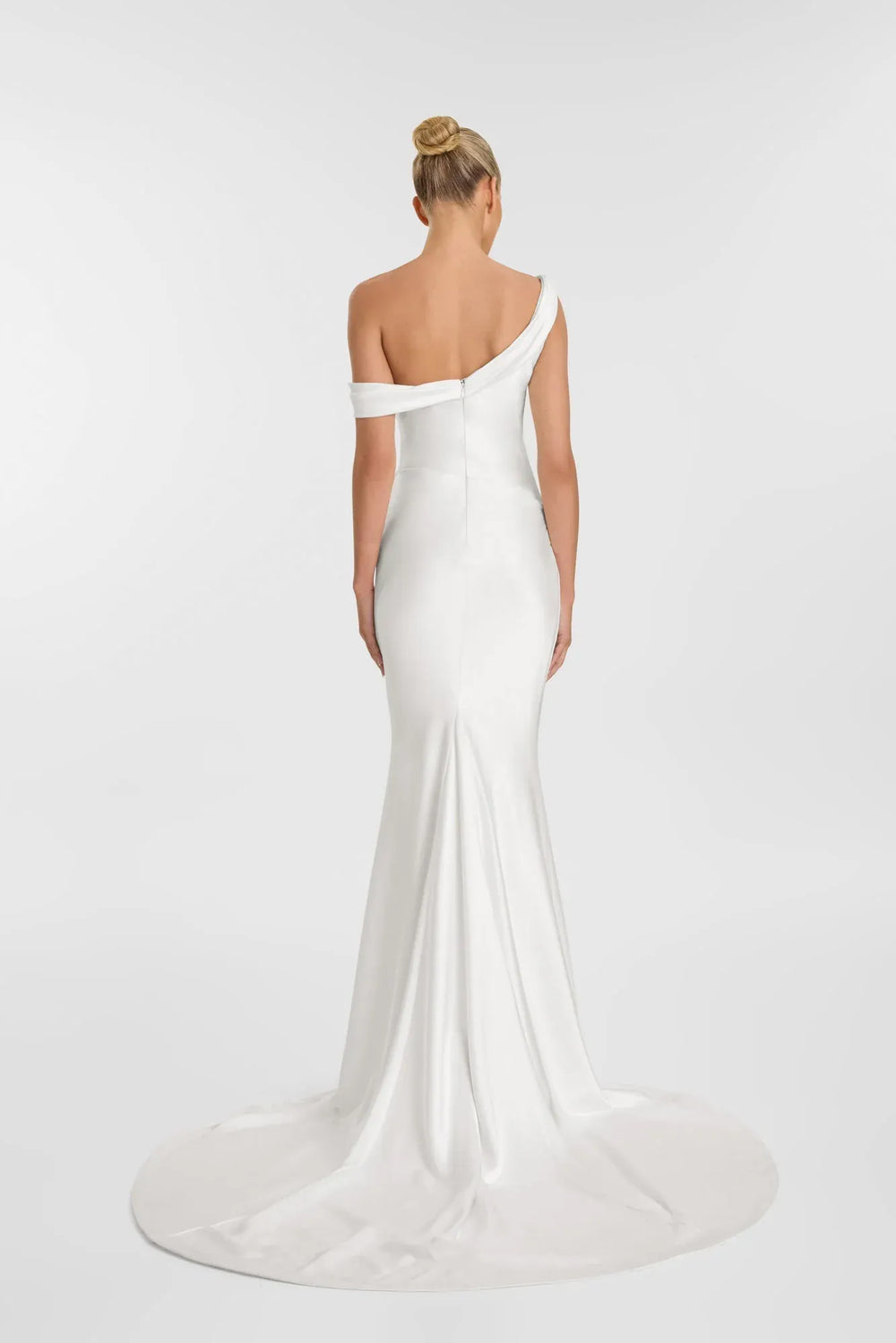 Woman wearing a white off-shoulder gown on a plain background