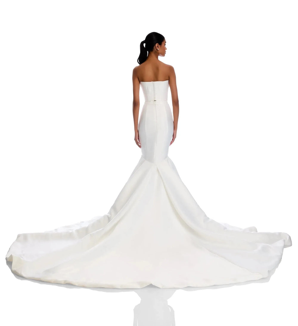 White strapless wedding dress with a long train on a white background