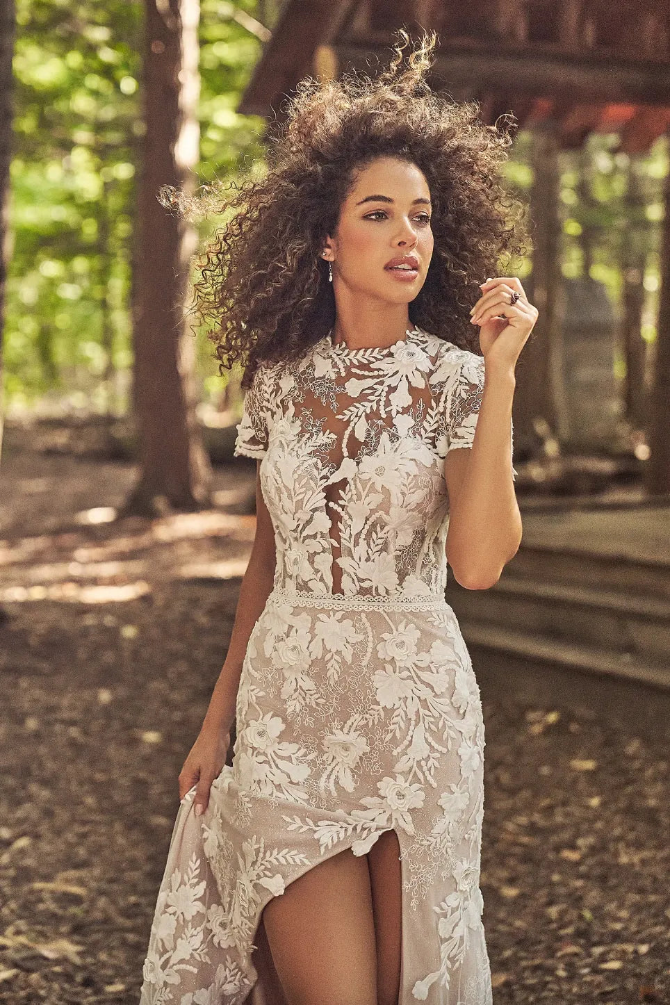 Woman in a floral dress standing in a forest setting