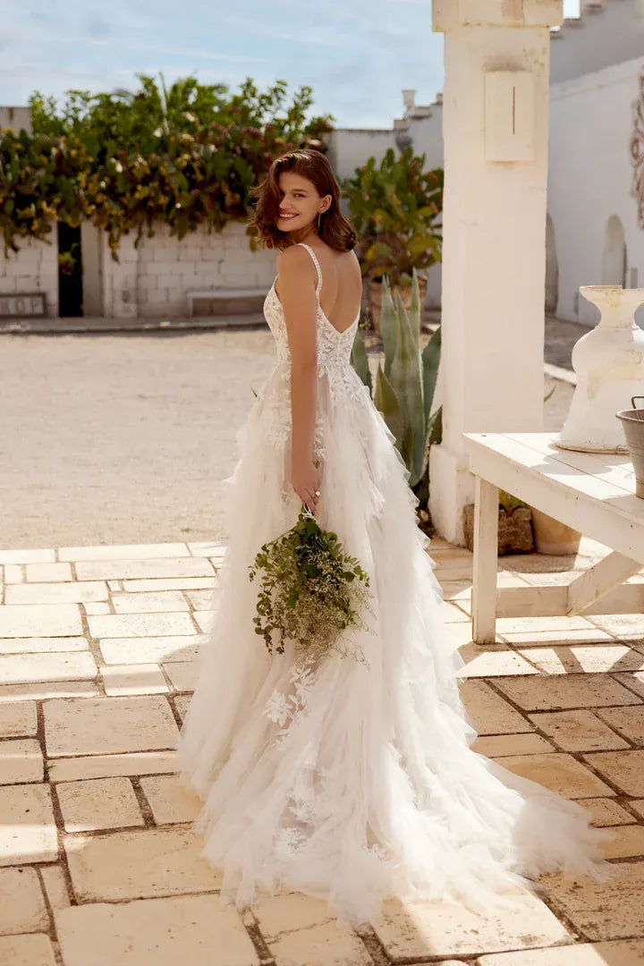 full back of lillian west 66407 champagne tulle a-line wedding dress featuring an open back and ruffled skirt and train