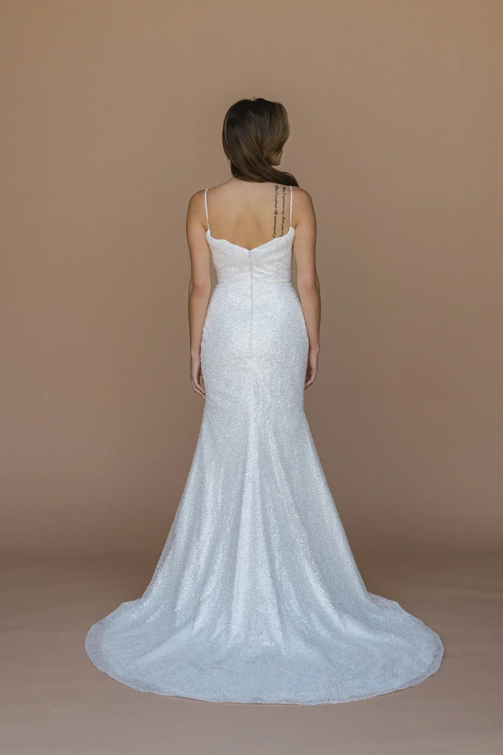 Woman wearing a white wedding dress with a plain background