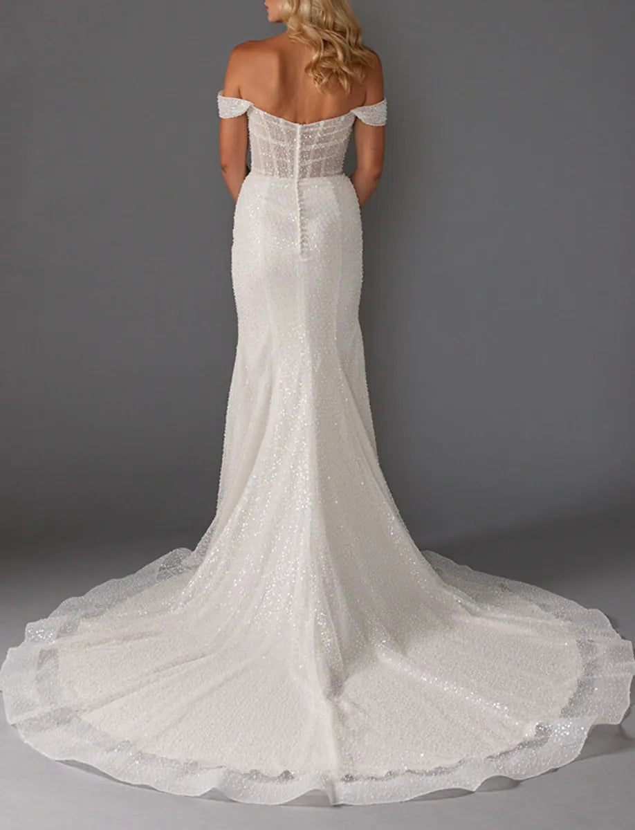 White lace wedding dress with a long train on a gray background