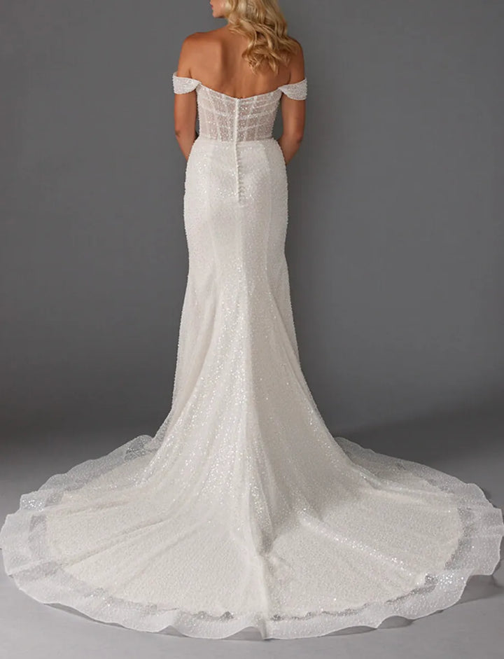 White lace wedding dress with a long train on a gray background