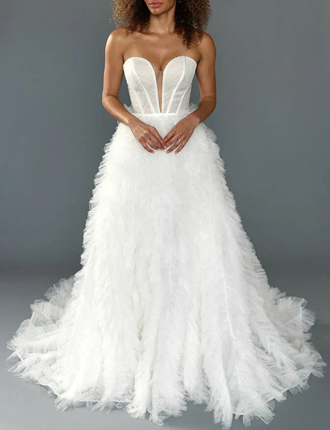 White wedding dress with a ruffled skirt on a gray background