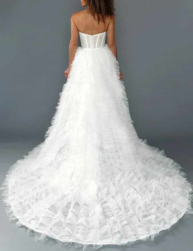 White wedding dress with ruffled skirt on a gray background