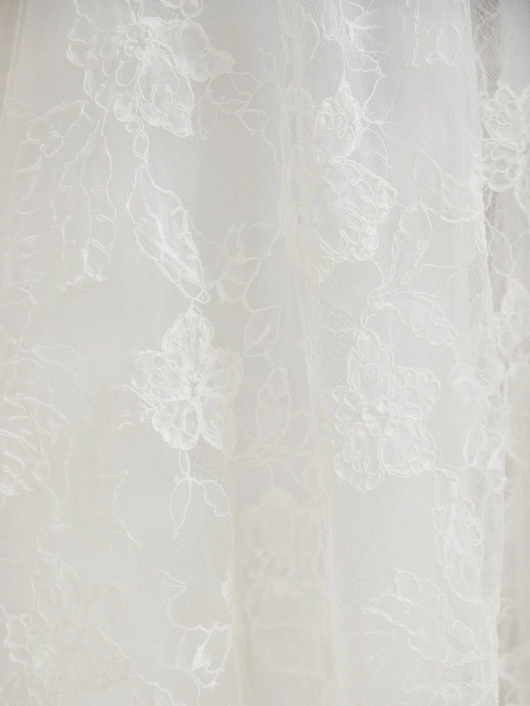 White floral lace fabric with delicate embroidered details and sheer tulle texture.