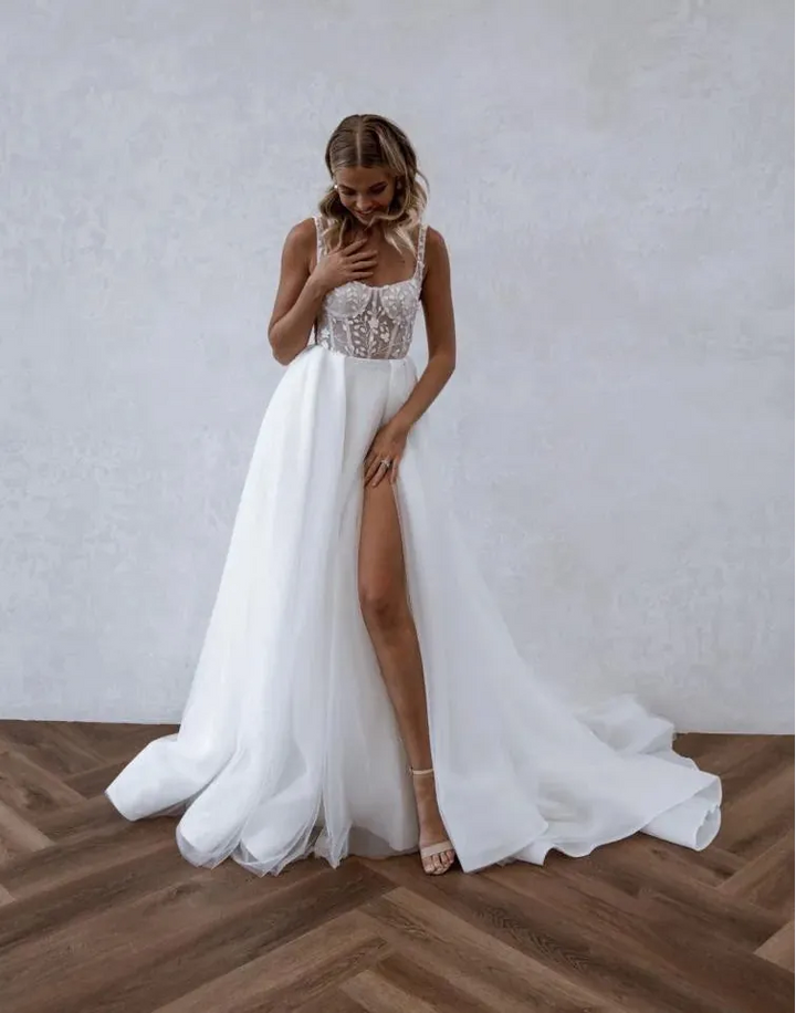 front of made with love huxley ivory tulle a-line wedding dress with a floral lace bodice and slit in the skirt