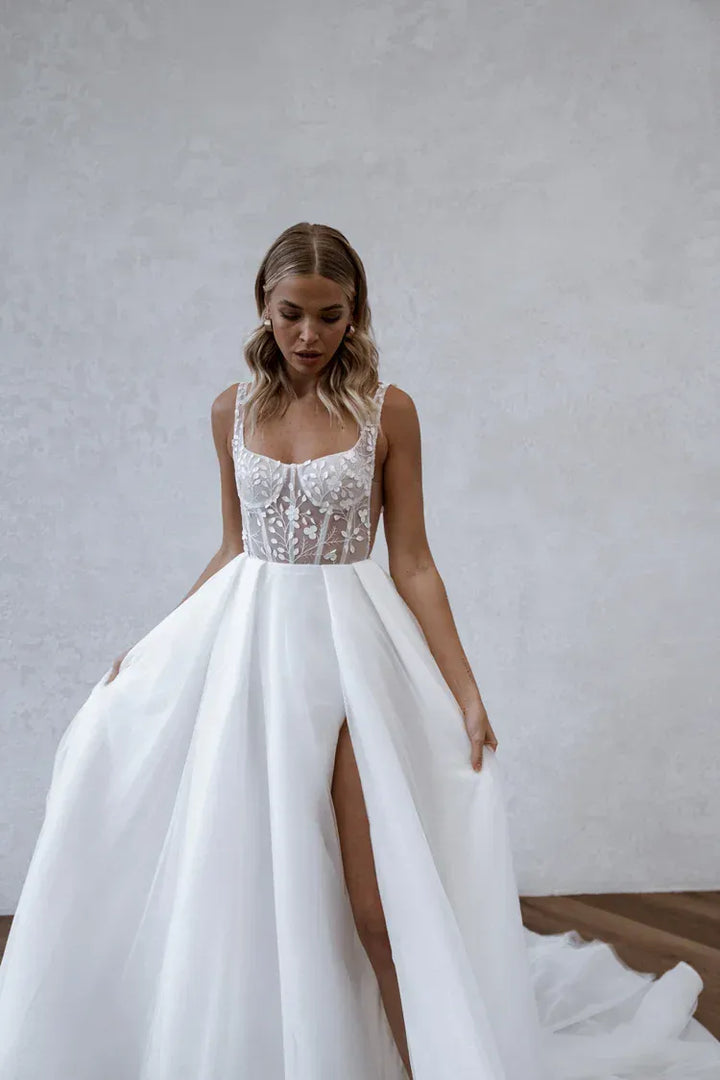close up of made with love huxley ivory tulle a-line wedding dress with a floral lace bodice and slit in the skirt