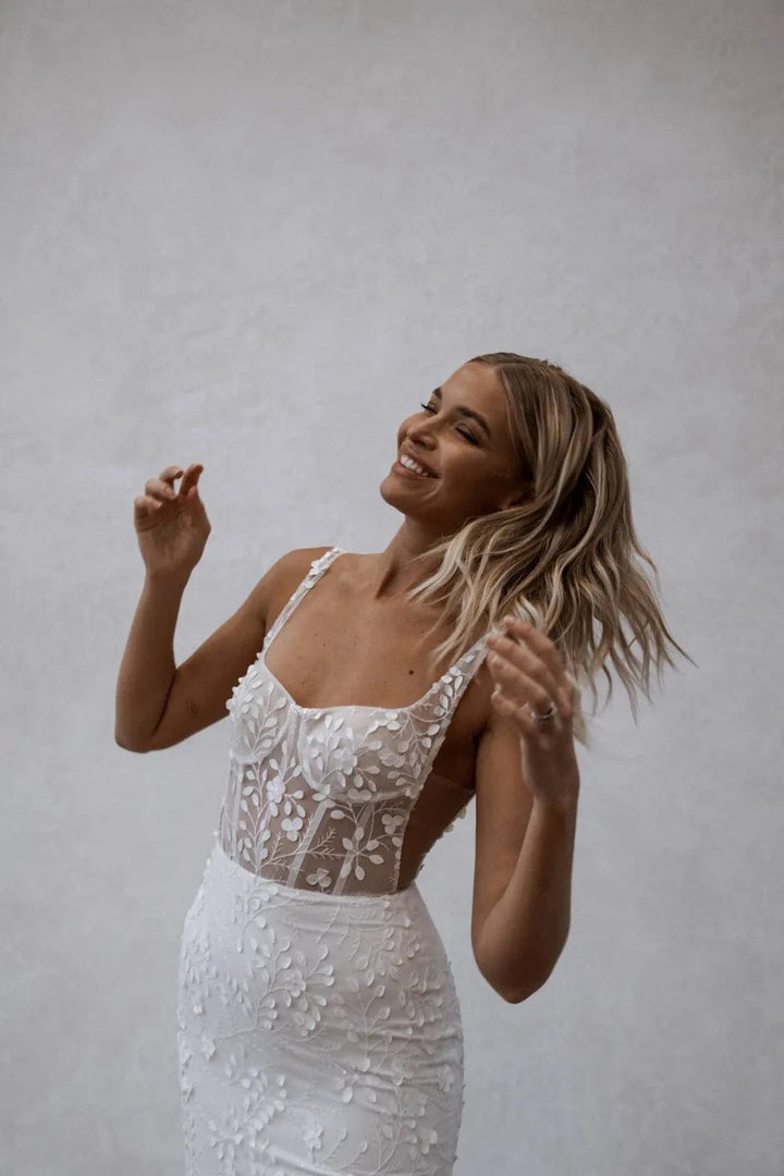 close up of made with love huxley ivory lace fitted wedding dress with a semi sheer bodice and square neckline
