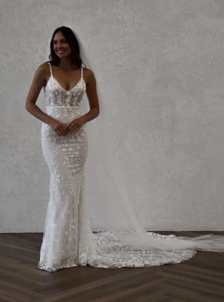 full front of made with love remi pebble colored lace fitted wedding dress with a v neckline and long train