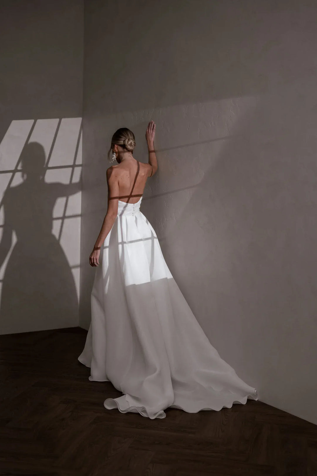 full back of made with love sloane ivory organza a-line wedding dress with a strapless bodice and flowy train at the back