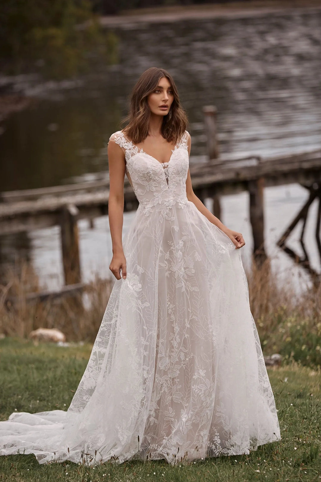full front of madi lane camille ivory lace a-line wedding dress with a deep v neckline and cap sleeves
