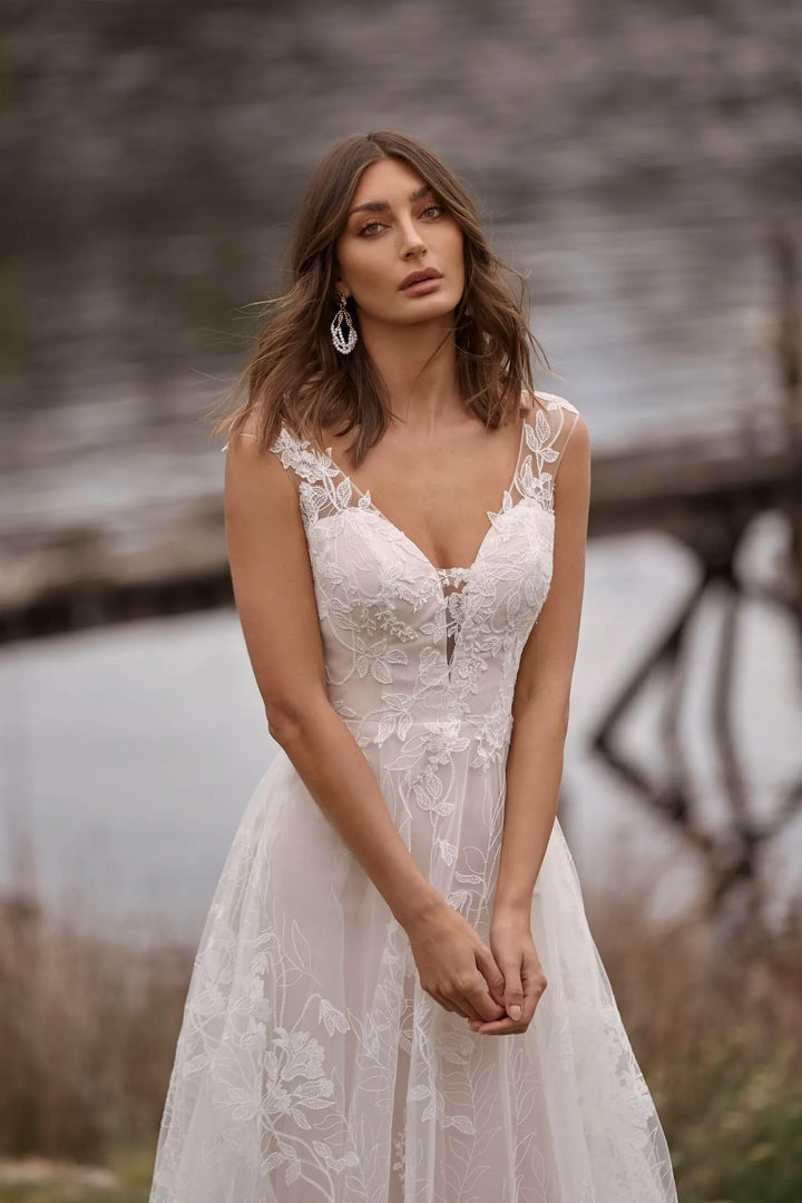 close up of madi lane camille ivory lace a-line wedding dress with a deep v neckline and cap sleeves