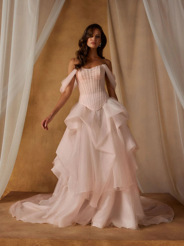 front of madi lane nickel and novella set. the nickel bodice has a basque waist and off the shoulder straps, paired with the layered tulle novella skirt